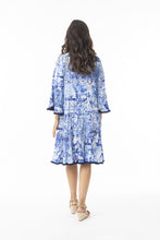 Load image into Gallery viewer, Orientique Okayama printed open neck tassel and tiered organic cotton dress displayed with flowy fabric and intricate pattern details.
