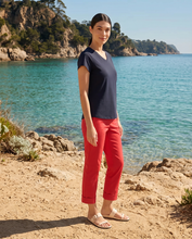Load image into Gallery viewer, Foil Signature Fuss Free Plain Capri 7/8 stretch trapeze trousers in vibrant poppy color, styled in natural lighting.