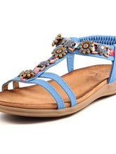 Load image into Gallery viewer, Lunar Feast blue T-bar open toe sandals with floral ribbon trim and elasticated back, stylish and comfortable for warm weather.