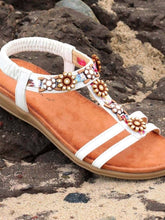 Load image into Gallery viewer, Lunar Feast white T-Bar open toe sandals with floral ribbon trim, elasticated back, and floral accents.