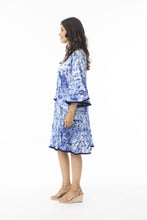 Load image into Gallery viewer, Orientique Okayama printed open neck tassel dress with tiered organic cotton fabric, featuring a relaxed fit and vibrant floral pattern.
