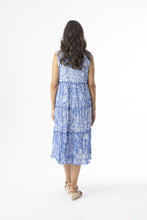 Load image into Gallery viewer, Orientique Aksharay blue sleeveless boho dress with tassel details and tiered organic cotton print, perfect for casual summer wear.
