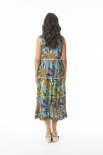 Load image into Gallery viewer, Orientique Tayrona sleeveless open-neck tassel dress with tiered organic cotton print, seen in natural outdoor setting.
