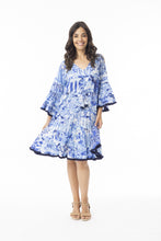 Load image into Gallery viewer, Light blue Orientique Okayama printed open neck tassel and tiered organic cotton dress displayed on a hanger.
